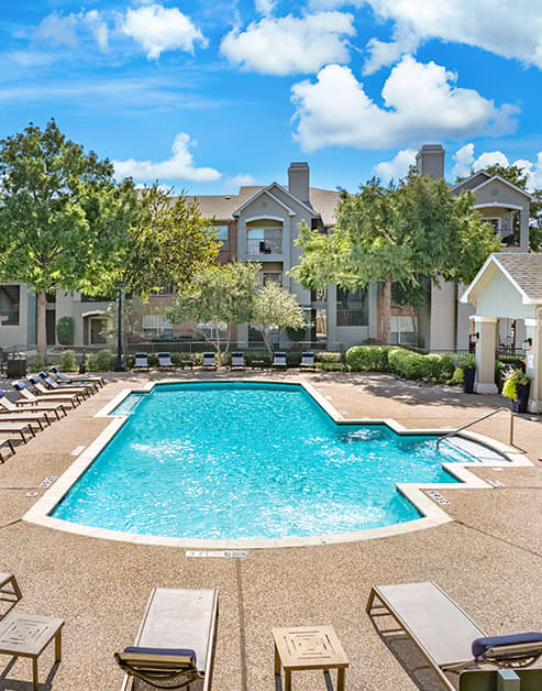 Swimming pool with lounge chairs at MAA Shoal Creek luxury apartments in Bedford, TX
