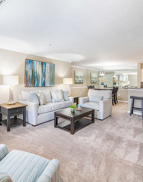 Open model living room space with light-colored couch and brown coffee table at MAA Berkeley Lake luxury apartments in Duluth, GA