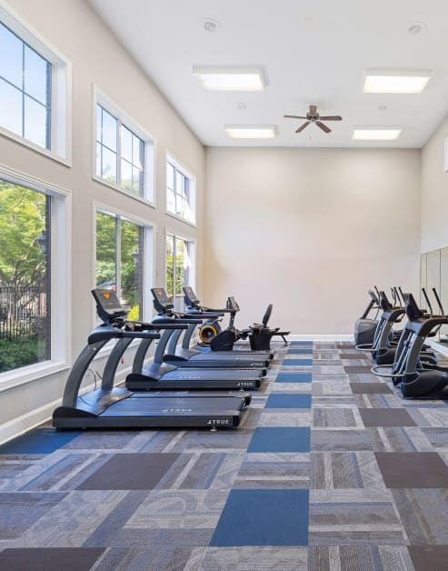 State-of-the-art fitness center with treadmill stations next to picture window views at MAA Shiloh luxury apartments in Kennesaw, GA