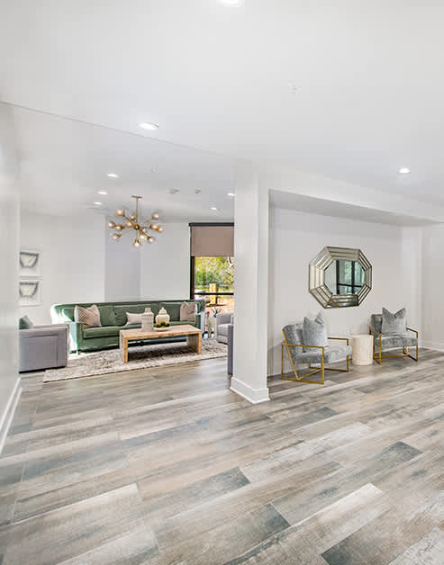 Community clubhouse featuring hardwood floors and stylish sitting areas shared with leasing office that offers a business center at MAA Gallery luxury apartments in Dallas, TX.