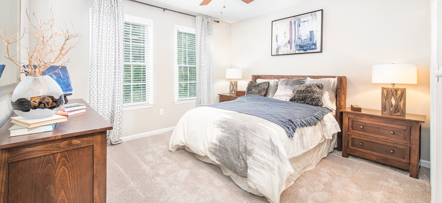 Model bedroom with natural filtered light and rustic wood bed set at MAA Riverside luxury apartments in Atlanta, GA