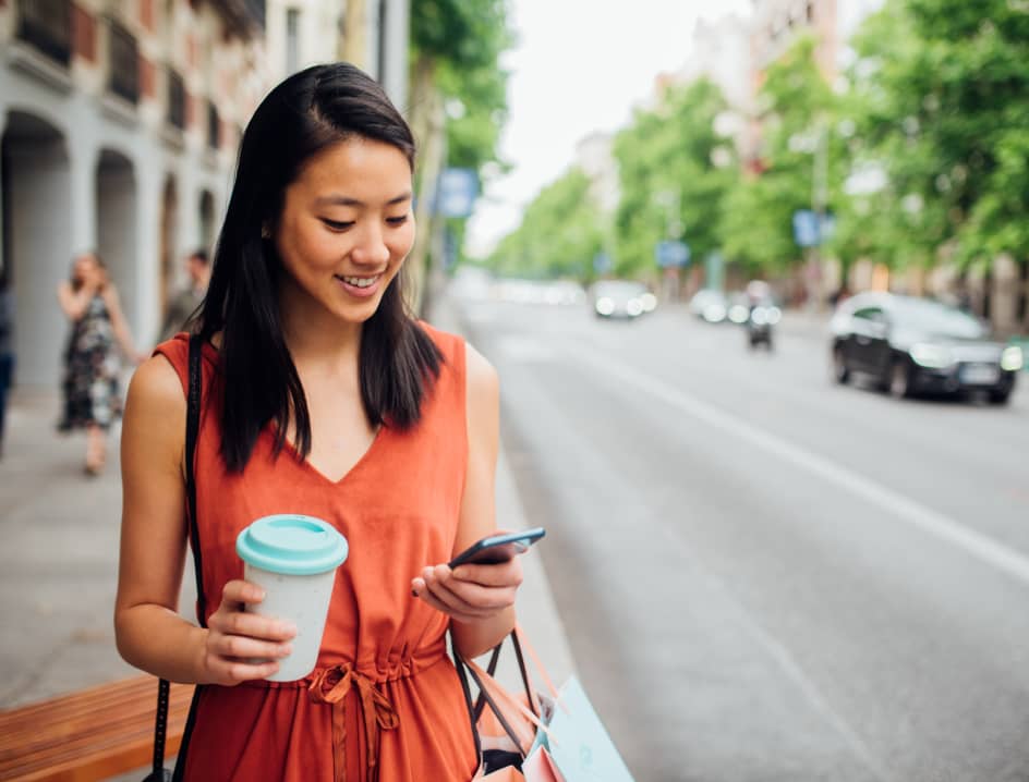 Woman with coffee checking her phone