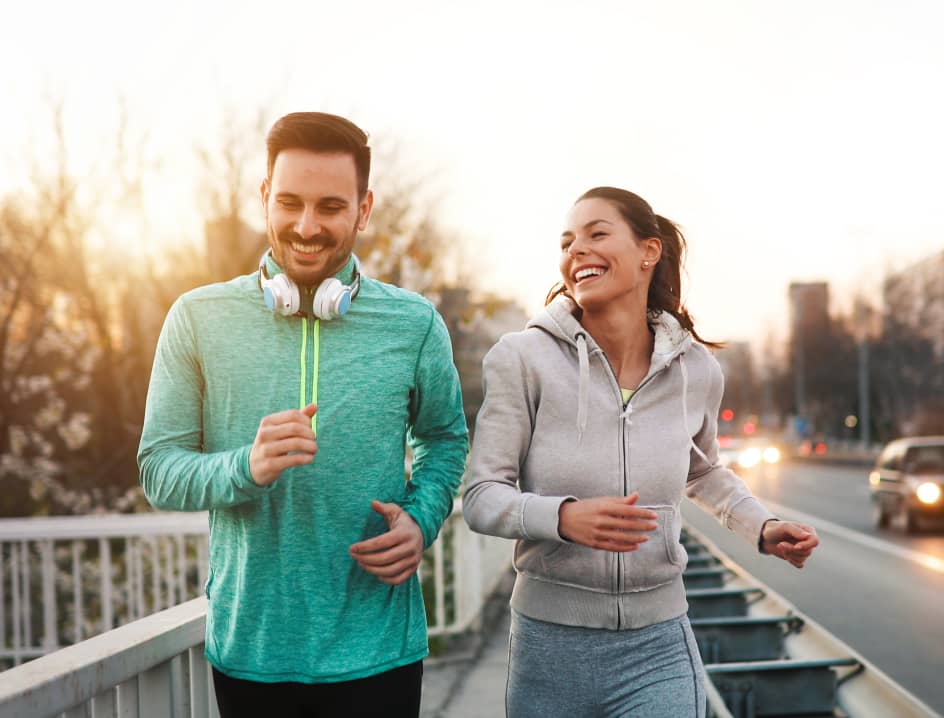 Man and woman run side by side smiling