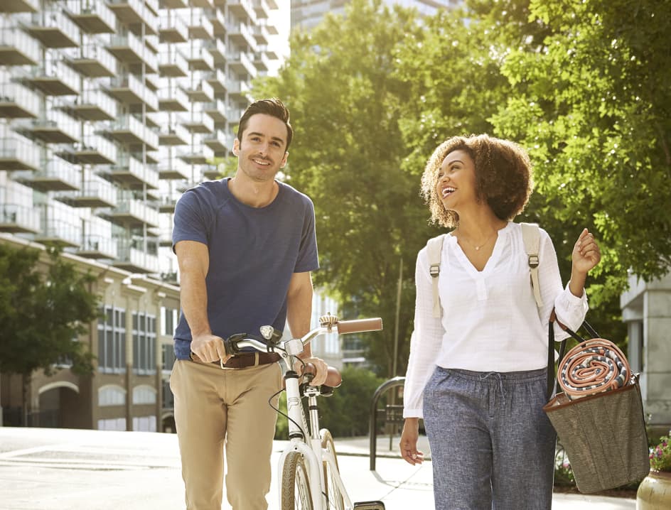Man with bike walks with woman smiling