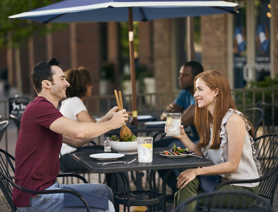 Woman and man sit down at restaurant to eat