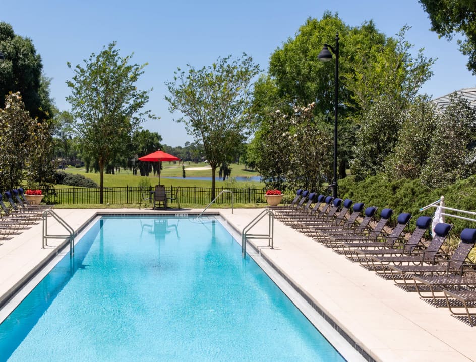 Swimming pool with lounge chairs at MAA Heathrow luxury apartments in Orlando, FL