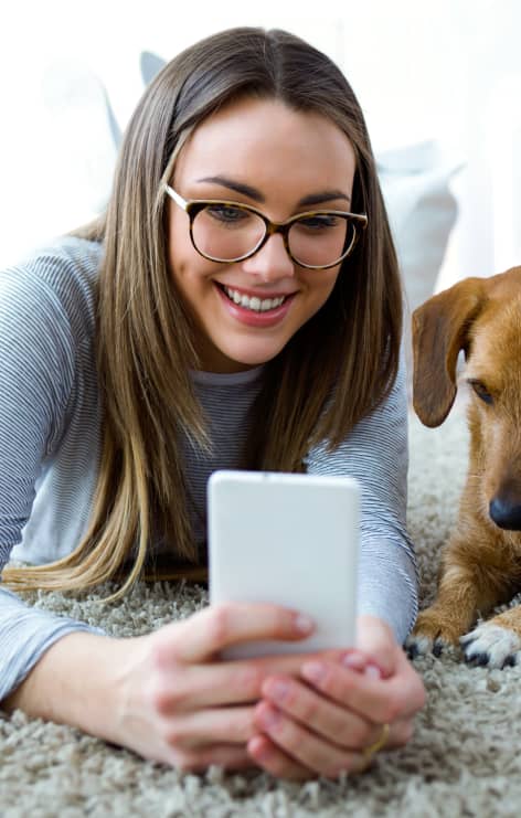 Woman holds a phone on the floor with dog