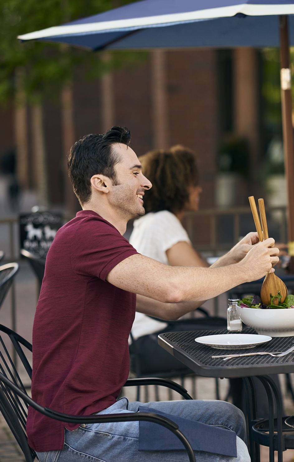 Woman and man sit down at restaurant to eat