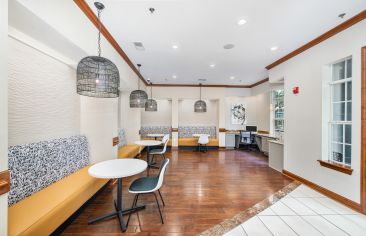 Cyber café lounge with tables and chairs and workstation at MAA Lenox luxury apartment homes in Atlanta, GA