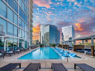 Outward view of rooftop wading pool with sun shelf surrounded by cabana-style lounging area at MAA Lenox luxury apartment homes in Atlanta, GA