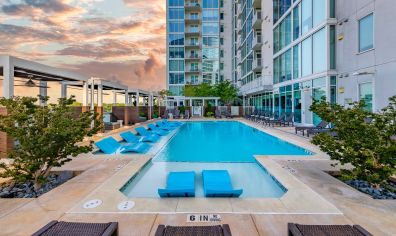 Inward view of rooftop wading pool with sun shelf surrounded by cabana-style lounging area at MAA Lenox luxury apartment homes in Atlanta, GA