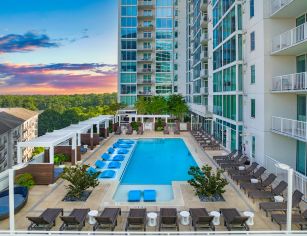 Aerial inward view of rooftop wading pool with sun shelf surrounded by cabana-style lounging area at MAA Lenox luxury apartment homes in Atlanta, GA