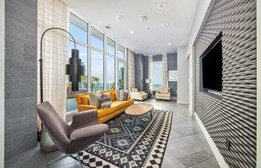 Relaxing rooftop lounge area with couches, TV and skyline views at MAA Lenox luxury apartments in Atlanta, GA