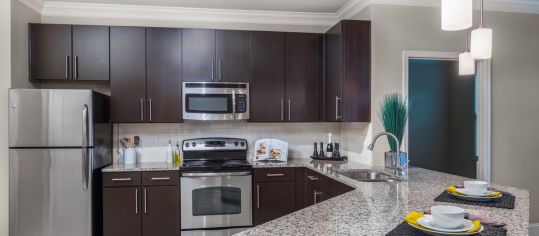 Kitchen with stainless steel appliances and granite countertops at MAA West Village luxury apartment homes in Atlanta, GA