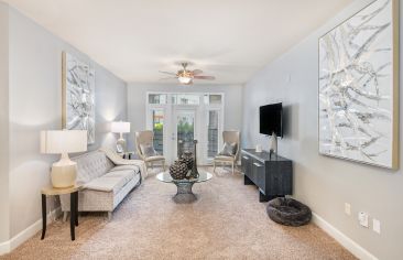 Spacious modern style living room with French doors to patio area at Market Station luxury apartments in Kansas City, MO