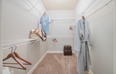 Carpeted walk-in closet with double shelving and storage space at Market Station luxury apartments in Kansas City, MO