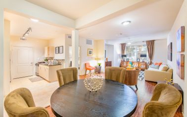 Upscale open floorplan dining area includes round dining table and cushioned chairs at MAA Heights luxury apartments in Dallas, TX