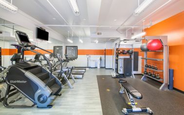 Upscale fitness center includes ellipticals, stair master, treadmills and weighted balls with workout area at MAA Heights luxury apartments in Dallas, TX