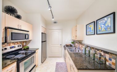 Modern kitchen with stainless steel appliances and granite countertops at MAA Heights luxury apartments in Dallas, TX