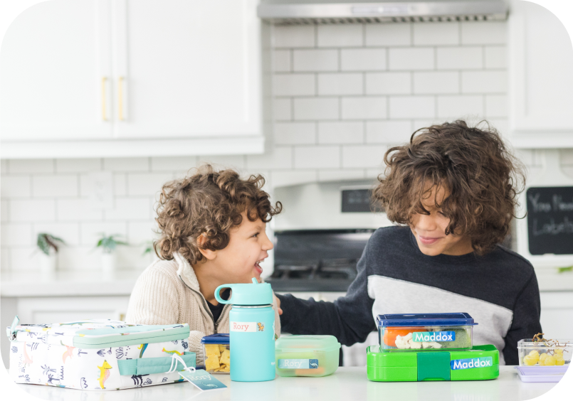 Siblings sitting at the kitchen counter together with Mabel's Labels products