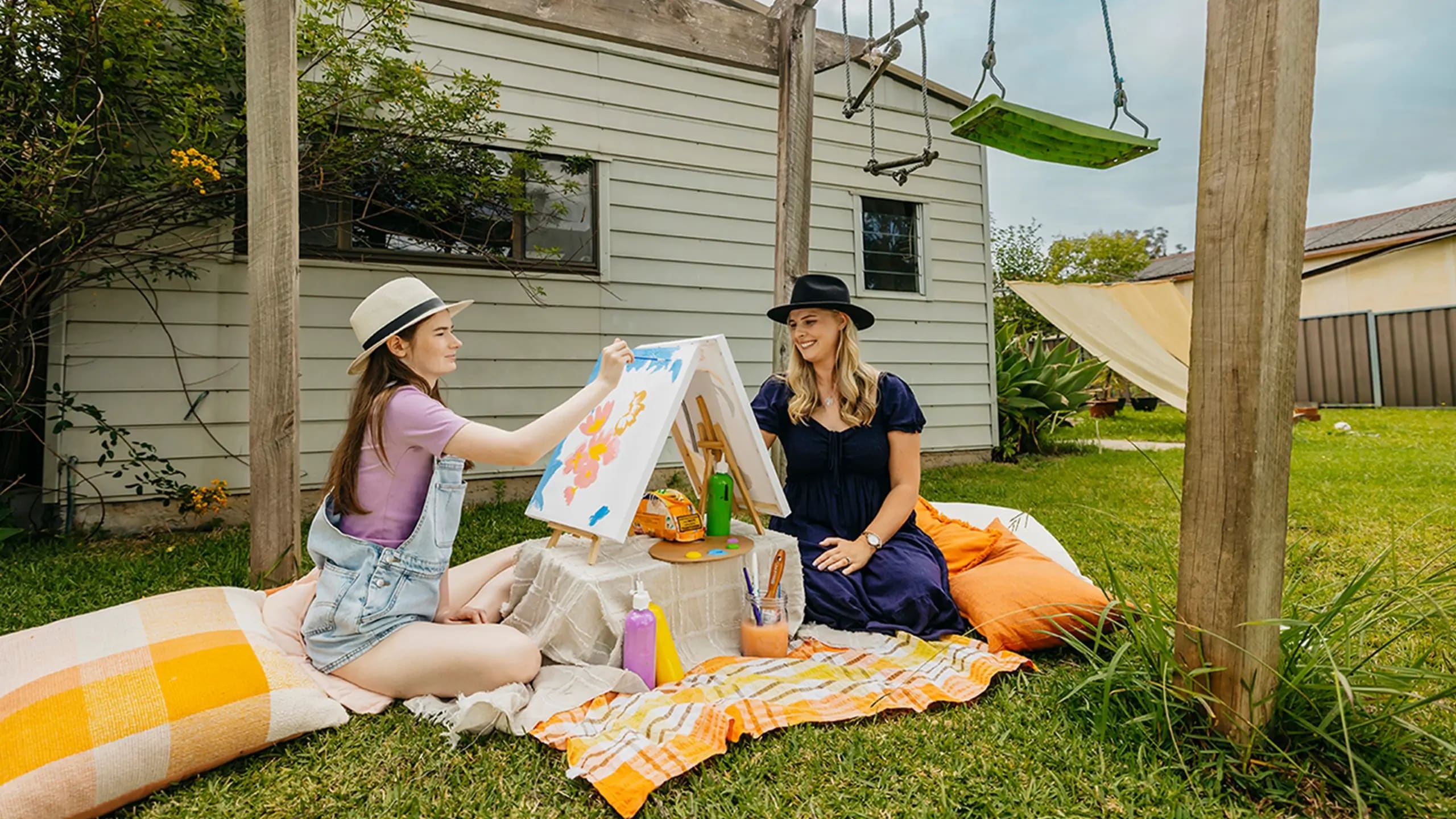 Occupational Therapist and teenager with autism paint outdoors for art therapy support session.