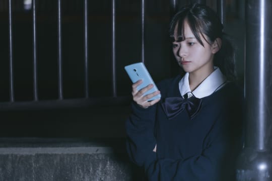 スマホを見る女子高生