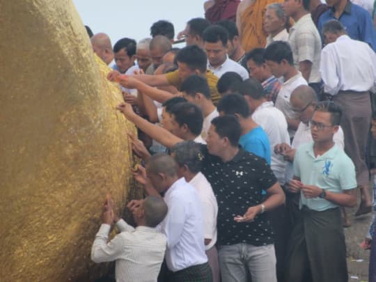 ゴールデンロックに金箔を貼る人々