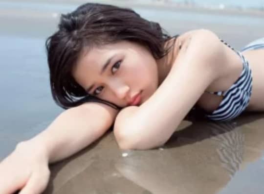 砂浜で腕枕する川口春奈