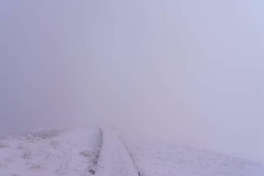 雪に覆われた稜線の木道