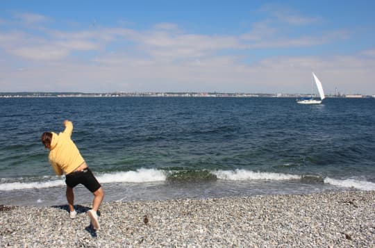 海に向かって物を投げる男性