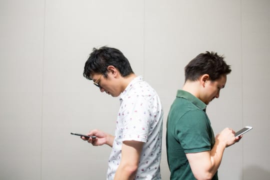 スマホを持つ男性2人