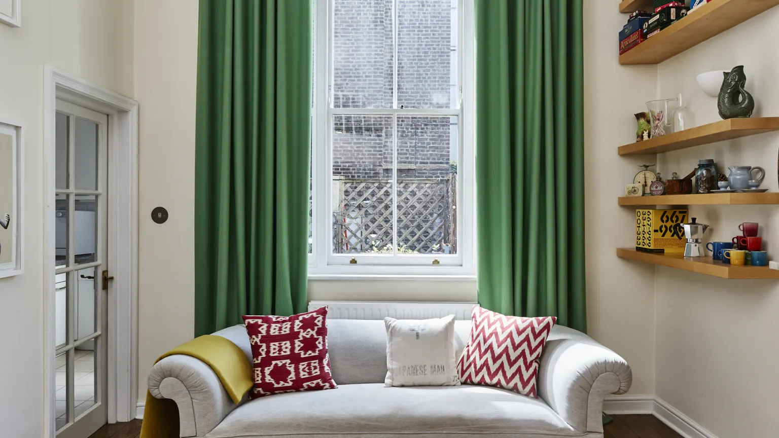 Living room with grey sofa and green woollen curtains