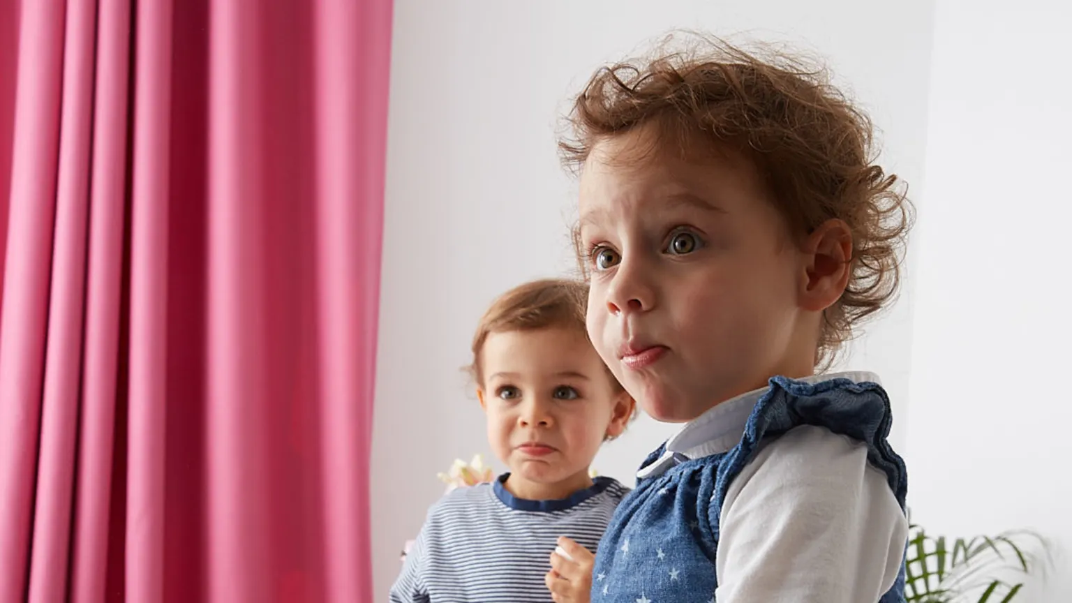 customer portrait of two children with tropical pink wool curtains in background