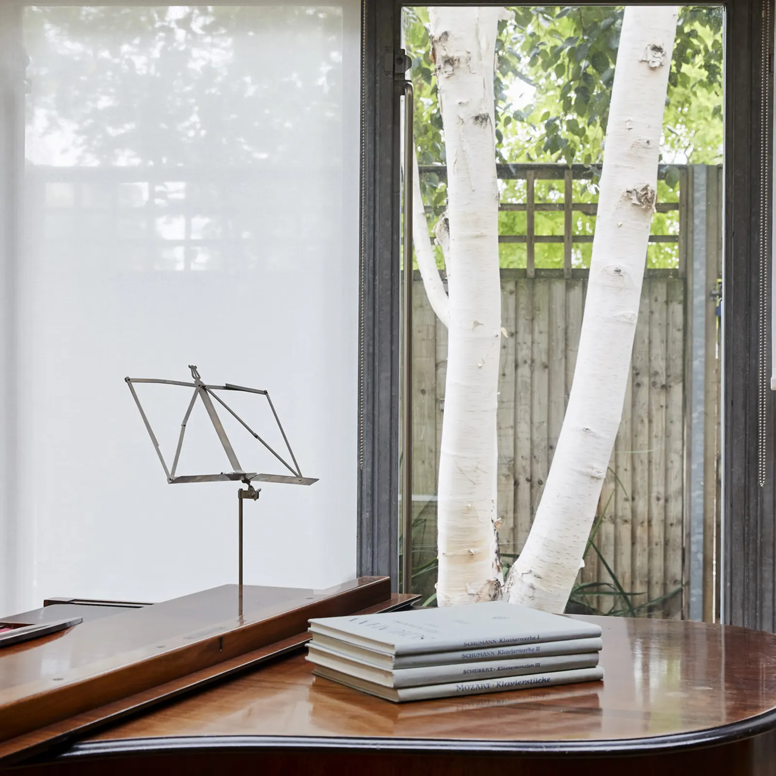 white transparent roller blinds with piano in foreground