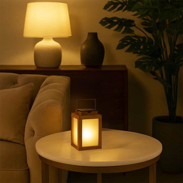 Warm lantern on round side table in cozy living room