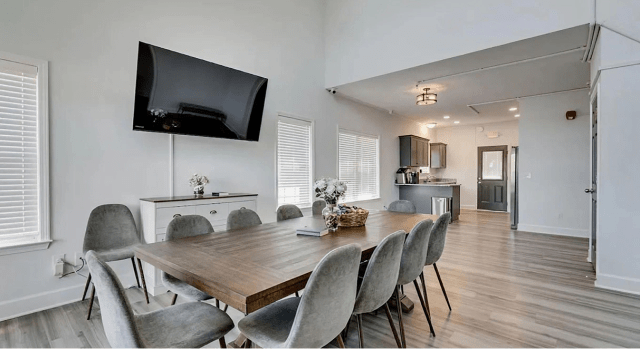 Spacious dining room with large table and kitchen area