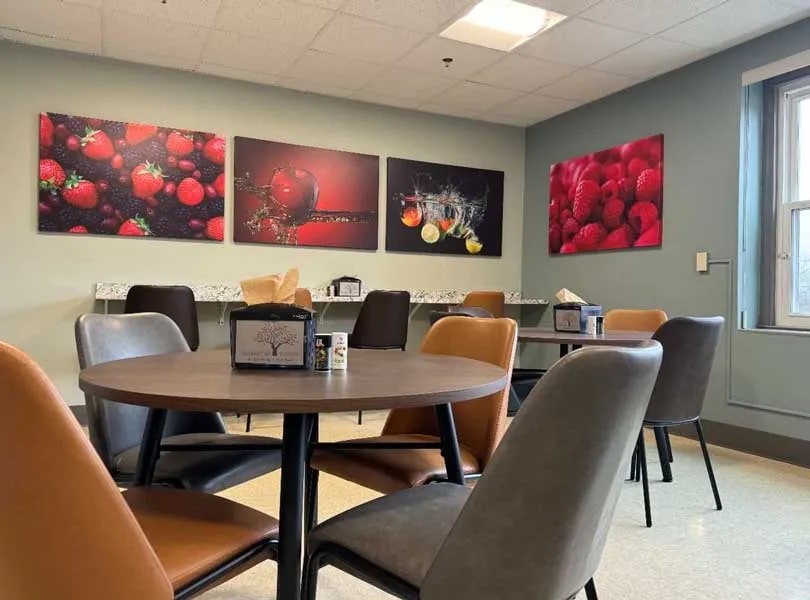 Communal dining area with round table and vibrant artwork