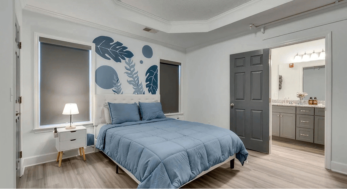 Modern bedroom with blue bedding and ensuite bathroom