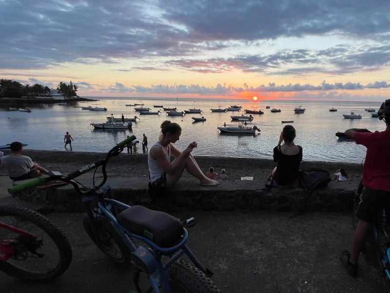 VTTistes au coucher de soleil sur la baie de l'Étang-Salé, voiliers à l'ancre et lagon, La Réunion