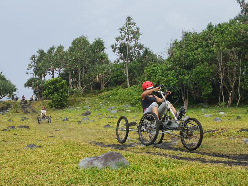 Deux quadbikes électriques Quadbike Runners sur sentier herbeux avec vacoas en arrière-plan, casques rouges, La Réunion
