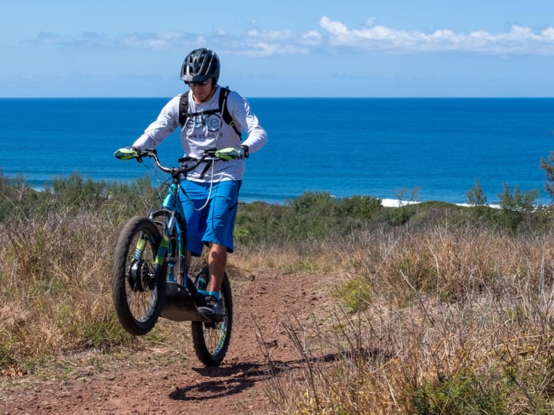 Rider en trott-cross électrique sur sentier littoral au-dessus de l'océan, forêt sèche de l'Étang-Salé, La Réunion