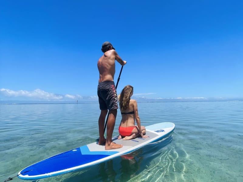 Couple en stand up paddle sur le lagon turquoise de La Saline-les-Bains, planche bleue et pagaie, La Réunion