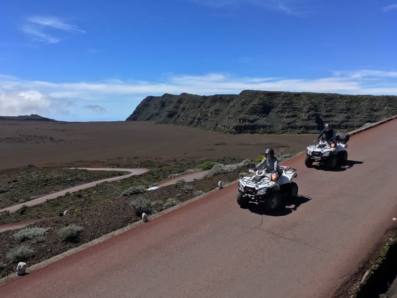 Deux quads Bourbon Excursions sur la route asphaltée qui traverse la Plaine des Sables, paysage volcanique de basalte et de scories rouges au Piton de la Fournaise, La Réunion