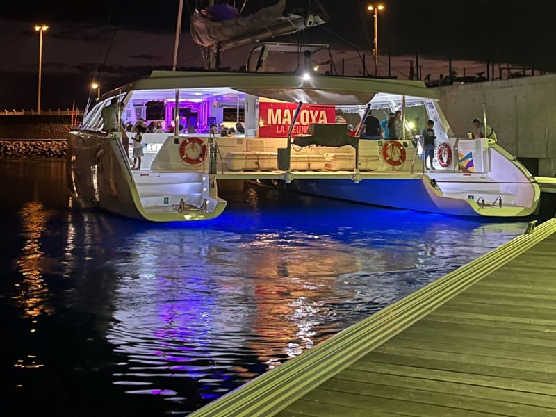 Catamaran Maloya éclairé au port la nuit à La Réunion, ambiance soirée et reflets bleus sur l'eau
