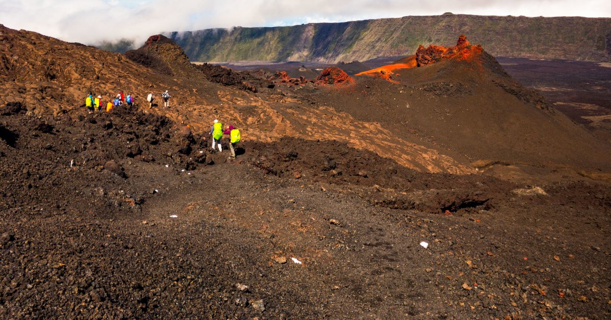 Hikers on Piton de la Fournaise with a local guide, Reunion Island, a volcanic landscape