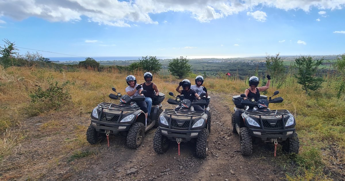 Three CF-MOTO quad bikes lined up in the highlands of Saint-Paul, Reunion Island, sea view in the background