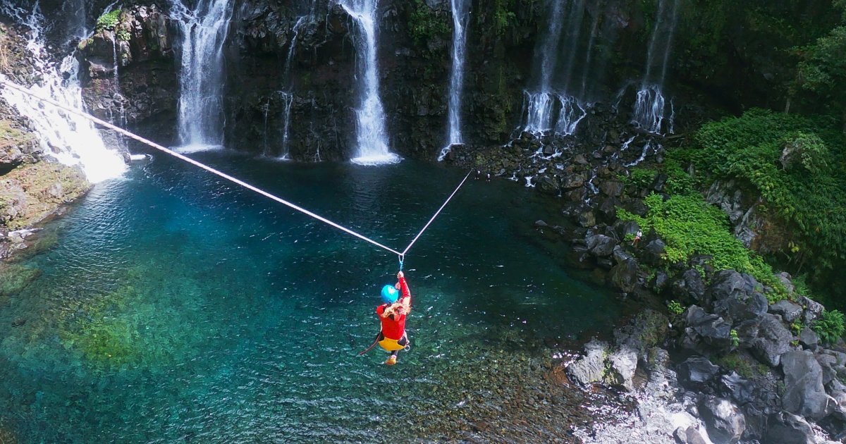 A zipline crossing above the Petit Galet pool on the Langevin river in Saint-Joseph, Reunion Island, waterfalls in the background
