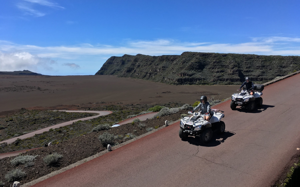 Deux quads Bourbon Excursions sur la route asphaltée qui traverse la Plaine des Sables, paysage volcanique de basalte et de scories rouges au Piton de la Fournaise, La Réunion