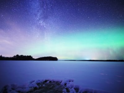 Experiencia en la sauna con la aurora boreal a orillas del lago, cerca de Rovaniemi