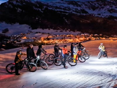 Descenso nocturno en bicicleta eléctrica de montaña sobre nieve en Le Grand-Bornand, cordillera de los Aravis